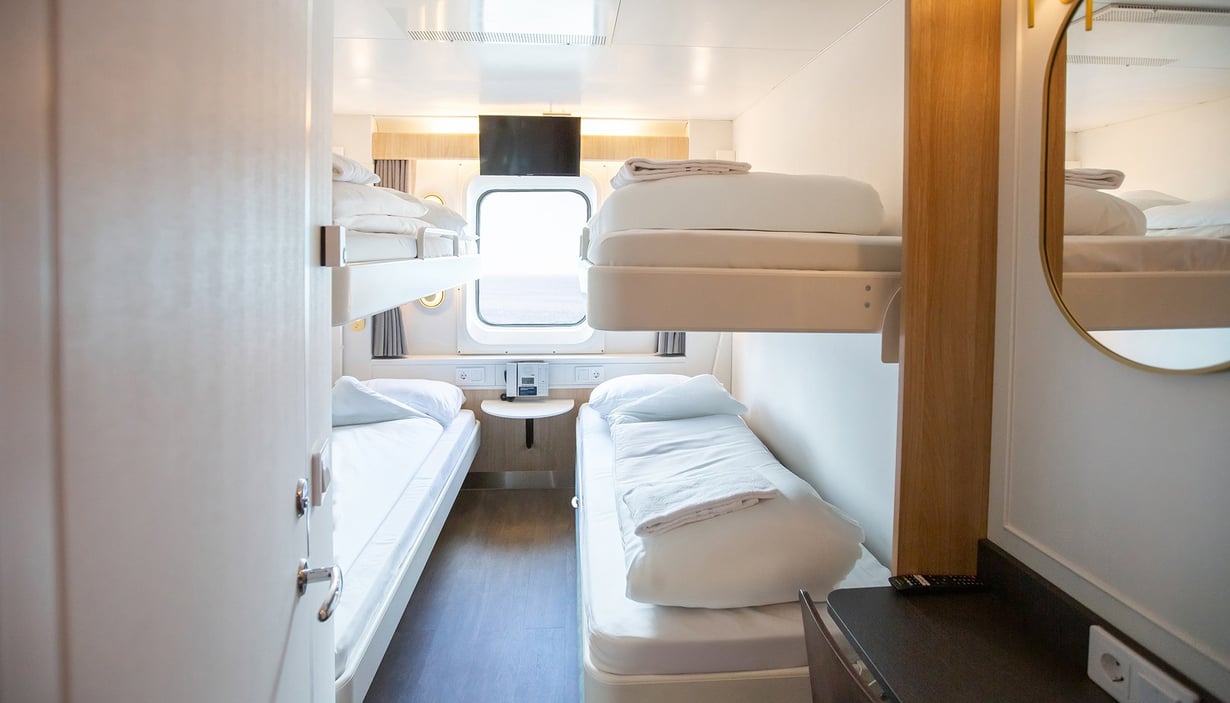 Kæledyrsvenlig kahyt med to sæt køjesenge og et vindue.