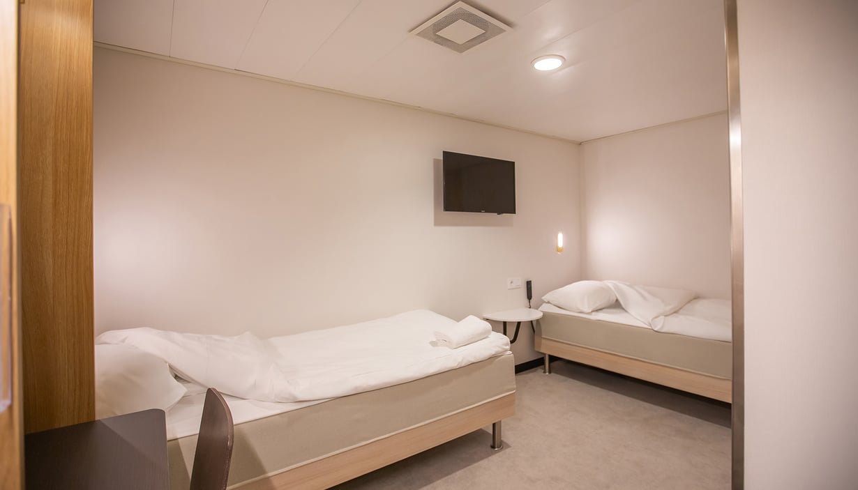 Handicapvenlig kahyt med to enkeltsenge og et rundt bord