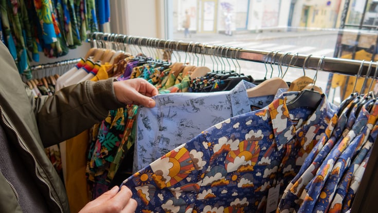 Person der kigger på skjorter i en tøjbutik i Oslo.