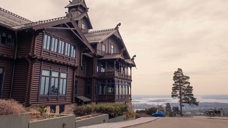 Stort træhus på en bakke med udsigt over vand nær Oslo.