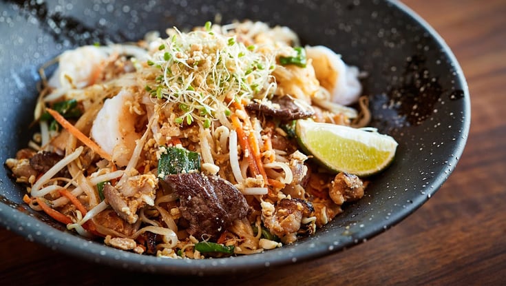 Nudelskål med kød, grøntsager og lime serveret i Oslo.