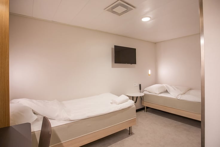 Handicapvenlig kahyt med to enkeltsenge og et rundt bord