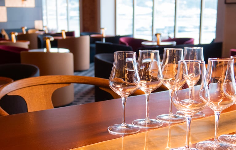 Række af tomme vinglas på en trædisk i en lounge.