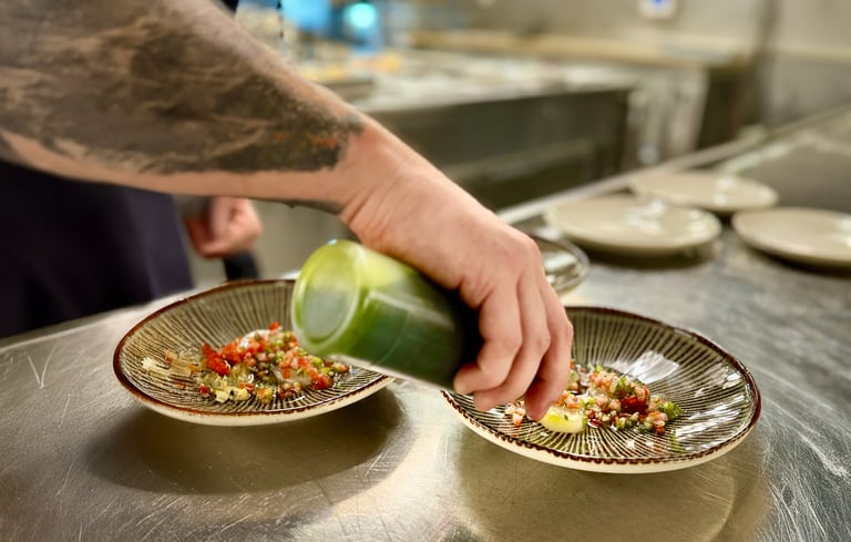 En kok der sætter mad på en tallerken