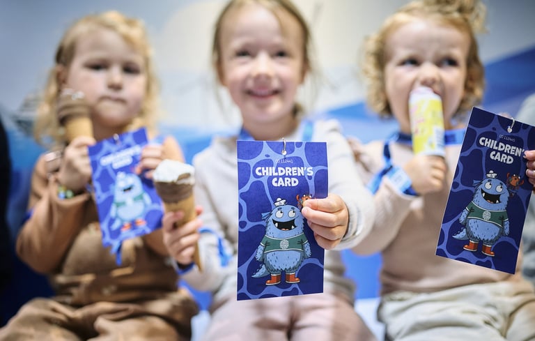 Tre børn, der holder "Children's Card"-hæfter med en tegneseriefigur i Matrosklubben.